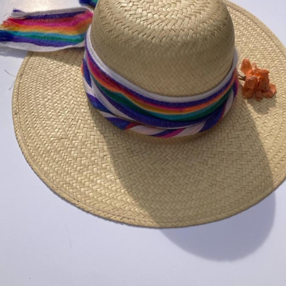 Tan straw hat with rainbow-colored ribbon and tassels